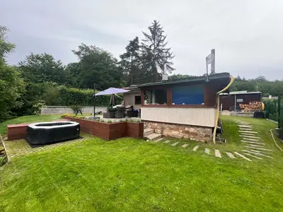 a house in a grassy yard with at Chata Miracle in Slapy