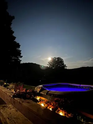 a lit up swimming pool in a yard at night at Chata Miracle in Slapy