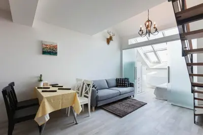 a living room with a couch and a table at Kent Ridge Loft, Sokolska in Prague