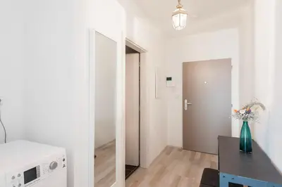 a white room with a vase of flowers on a table at Kent Ridge Loft, Sokolska in Prague
