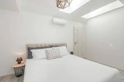 a white bedroom with a white bed and a lamp at Kent Ridge Loft, Sokolska in Prague