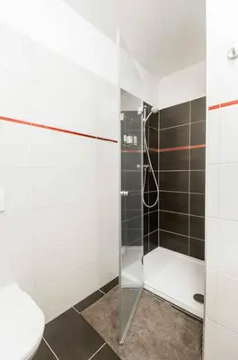 a bathroom with a glass shower with a toilet at Kent Ridge Loft, Sokolska in Prague