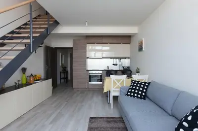 a living room with a blue couch and a kitchen at Kent Ridge Loft, Sokolska in Prague