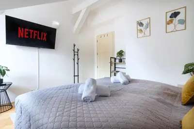 a bedroom with a large bed with a netflix sign on the wall at Duplex 165m2 with VIEWS only 30 Seconds to Charles Bridge in Prague