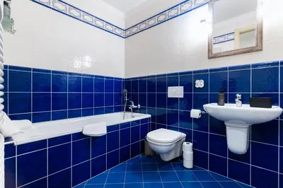 a blue tiled bathroom with a toilet and a sink at Duplex 165m2 with VIEWS only 30 Seconds to Charles Bridge in Prague