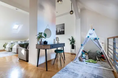 a living room with a table and a desk at Duplex 165m2 with VIEWS only 30 Seconds to Charles Bridge in Prague