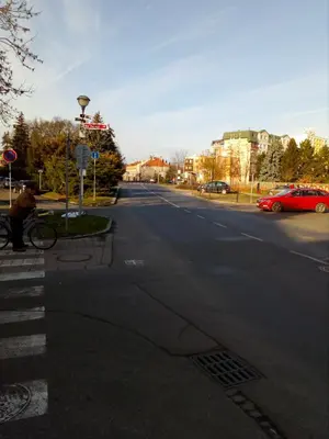 a person sitting on a bench on a street at Apartment Husova in Poděbrady