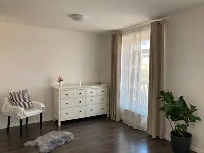 a bedroom with a white dresser and a window at Apartment Husova in Poděbrady