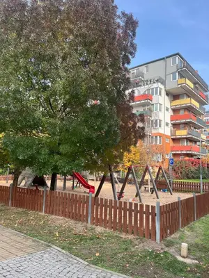 a park with a playground with a slide and trees at Family Arena Prague in Prague
