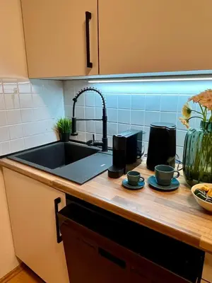 a kitchen with a sink and two cups on a counter at Family Arena Prague in Prague