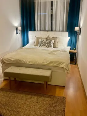a bedroom with a large bed with a bench on it at Family Arena Prague in Prague