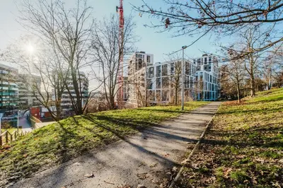 a path in a park in front of a building at Blueground Žižkov furnished park PRG-42 in Prague