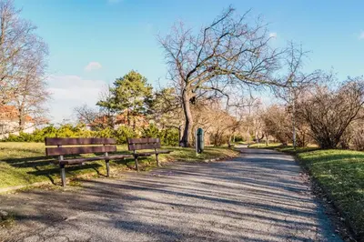 two park benches sitting on the side of a road at Blueground Žižkov furnished park PRG-42 in Prague
