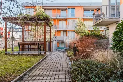 a walkway in front of a building with a bench at Blueground Žižkov furnished park PRG-42 in Prague