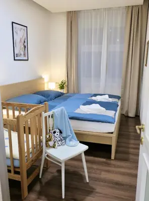 a bedroom with a bed and a chair and a crib at Charm Apartment Deco near Old Town, All-Friendly in Prague