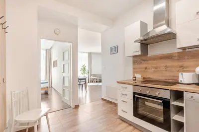 a kitchen with white cabinets and a wooden floor at Charm Apartment Deco near Old Town, All-Friendly in Prague