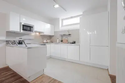 a white kitchen with white cabinets and a sink at Charming Duplex Loft in Prague Center in Prague
