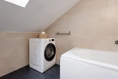 a washing machine in a bathroom next to a bath tub at Charming Duplex Loft in Prague Center in Prague