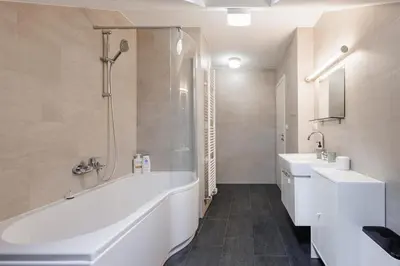 a white bathroom with a tub and a sink at Charming Duplex Loft in Prague Center in Prague