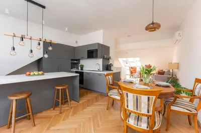 a kitchen and dining room with a table and chairs at Oomph Apartments in Prague