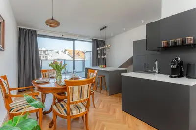 a kitchen and dining room with a table and chairs at Oomph Apartments in Prague
