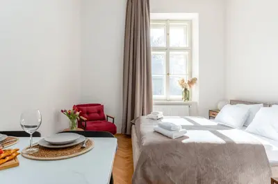 a bedroom with a bed and a table with a plate of food at Oomph Apartments in Prague