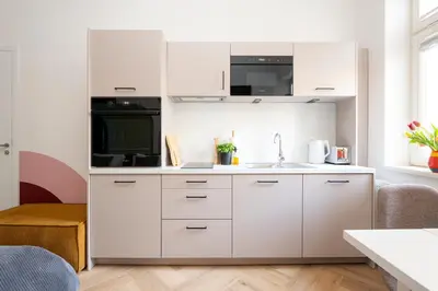 a kitchen with white cabinets and a sink at Oomph Apartments in Prague