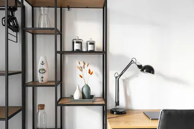 a room with a desk with a lamp and shelves at Oomph Apartments in Prague