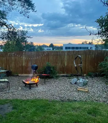 a backyard with a fire pit and a fence at Cottage by the Jizera river in Nový Vestec