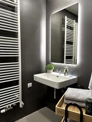a bathroom with a white sink and a mirror at Viktoria Suite N6 with Garage & Balcony in Prague