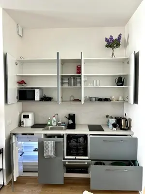 a kitchen with white counters and white shelves at Viktoria Suite N6 with Garage & Balcony in Prague