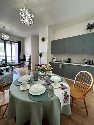a living room with a table and a kitchen at Viktoria Suite N6 with Garage & Balcony in Prague