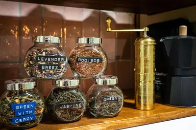a shelf with four glass jars of spices at PilotsApartments in Prague