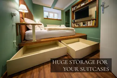 a bedroom with a bed with drawers and a tv at PilotsApartments in Prague