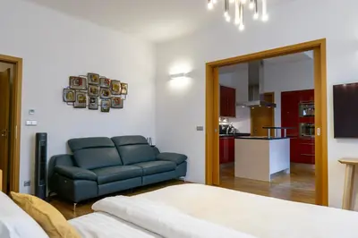 a living room with a blue couch and a kitchen at Michalská Residence by Old Town Square in Prague