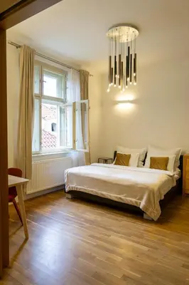 a bedroom with a large bed and a chandelier at Michalská Residence by Old Town Square in Prague