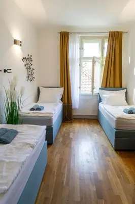 a room with three beds and a window at Michalská Residence by Old Town Square in Prague