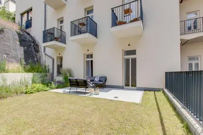 an apartment patio with a chair and grass at Visit Oomph Apartments in Prague