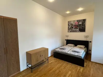 a bedroom with a bed and a painting on the wall at Cosy Studio with terrace near Florenc in Prague