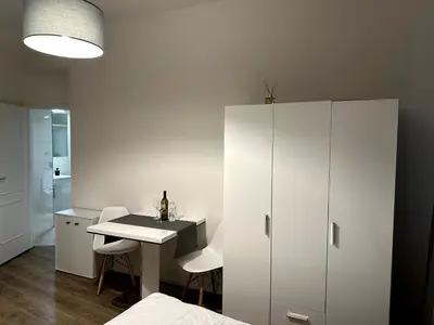 a room with a table and a white cabinet at Florenc Apartment in Prague