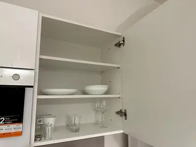 a white cupboard with bowls and glasses in it at Florenc Apartment in Prague