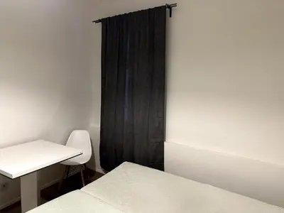 a bedroom with a bed and a desk and a curtain at Florenc Apartment in Prague