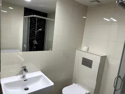 a white bathroom with a sink and a toilet at Florenc Apartment in Prague