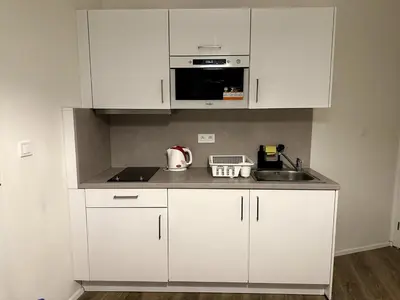 a kitchen with white cabinets and a sink at Florenc Apartment in Prague