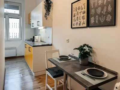 a kitchen with a table with two chairs and a counter top at SOEL apartments in Prague