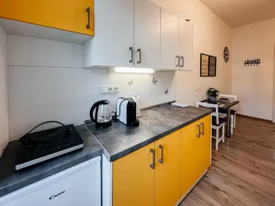 a kitchen with yellow cabinets and a counter top at SOEL apartments in Prague