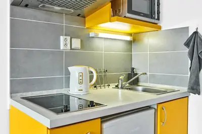 a kitchen with yellow cabinets and a sink at SOEL apartments in Prague