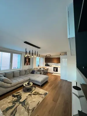 a large living room with a couch and a kitchen at Apartamenty Liben O2 in Prague