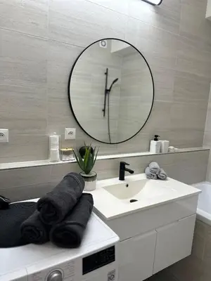 a white bathroom with a sink and a mirror at Apartamenty Liben O2 in Prague