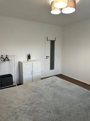 a white room with a door and a table at Apartamenty Liben O2 in Prague